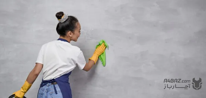 یک زن در حال تمیز کردن دیوار رنگ روغنی